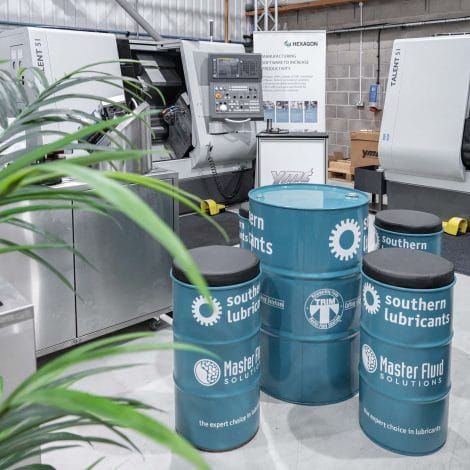 Workshop display featuring Hardinge Talent CNC lathes and Southern Lubricants barrels at YMT showroom, highlighting Master Fluid Solutions partnership.